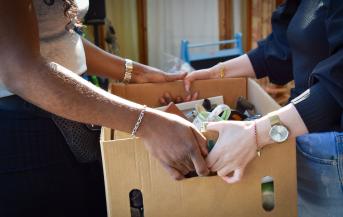 Une femme tend une caisse remplie de bibelots à une autre femme