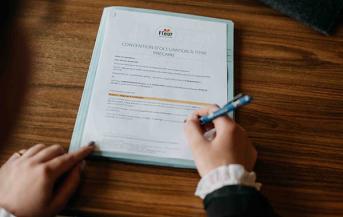 Deux mains signent un document officiel
